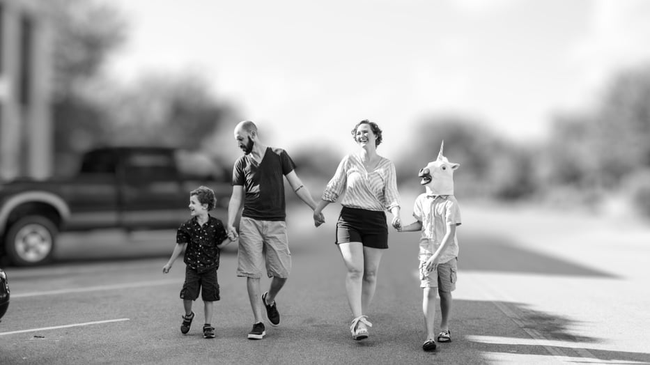 A joyful family walking hand in hand outdoors, representing the balance between entrepreneurship, family life, and everyday connection.