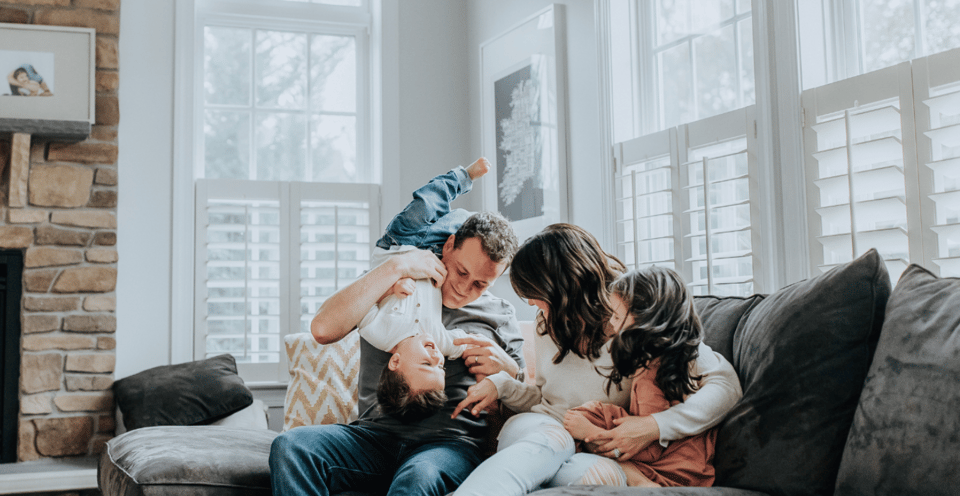 Happy family playing and snuggling together on the couch.